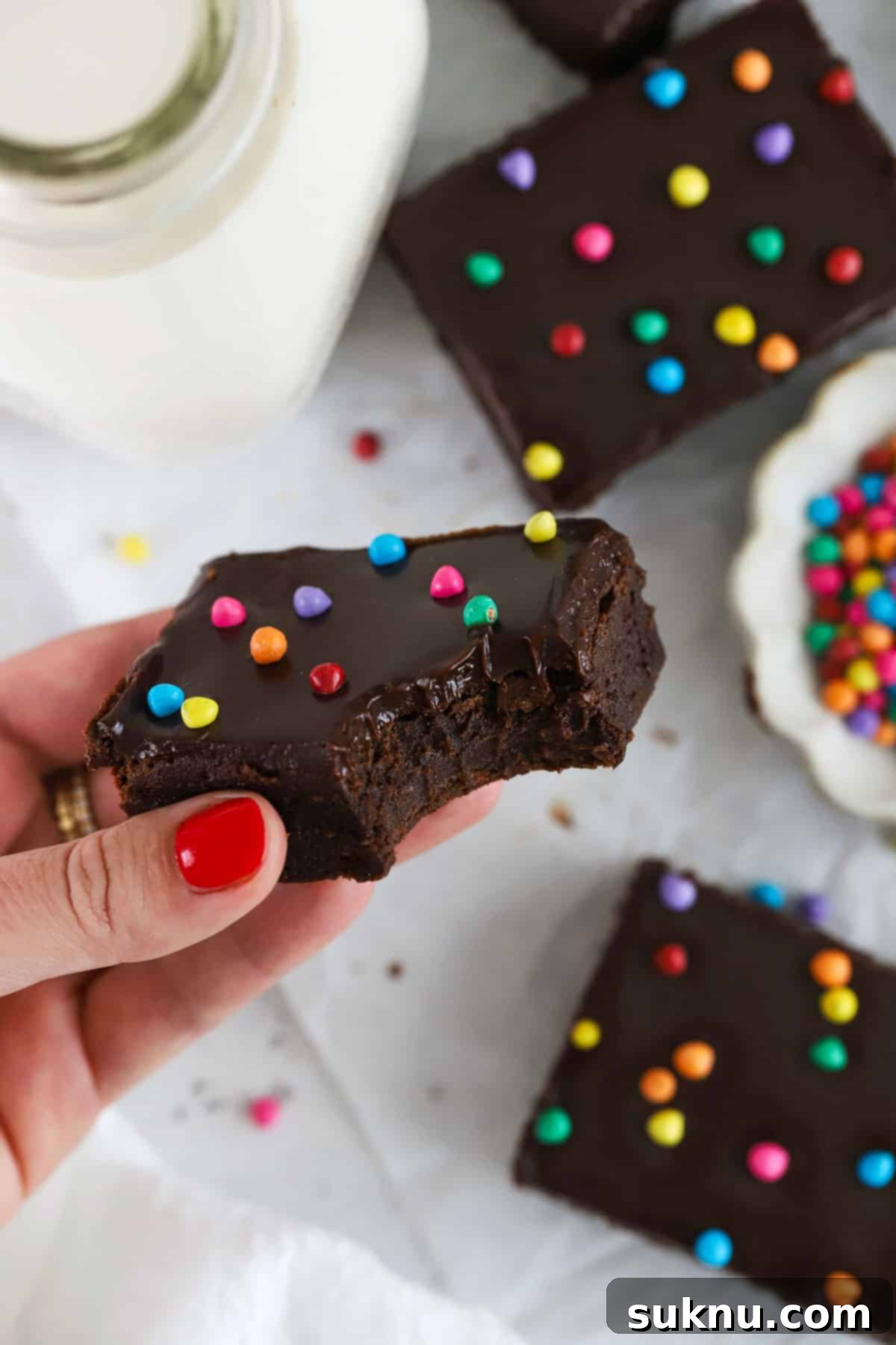 Holding up a gluten-free Cosmic brownie with a bite taken out of it