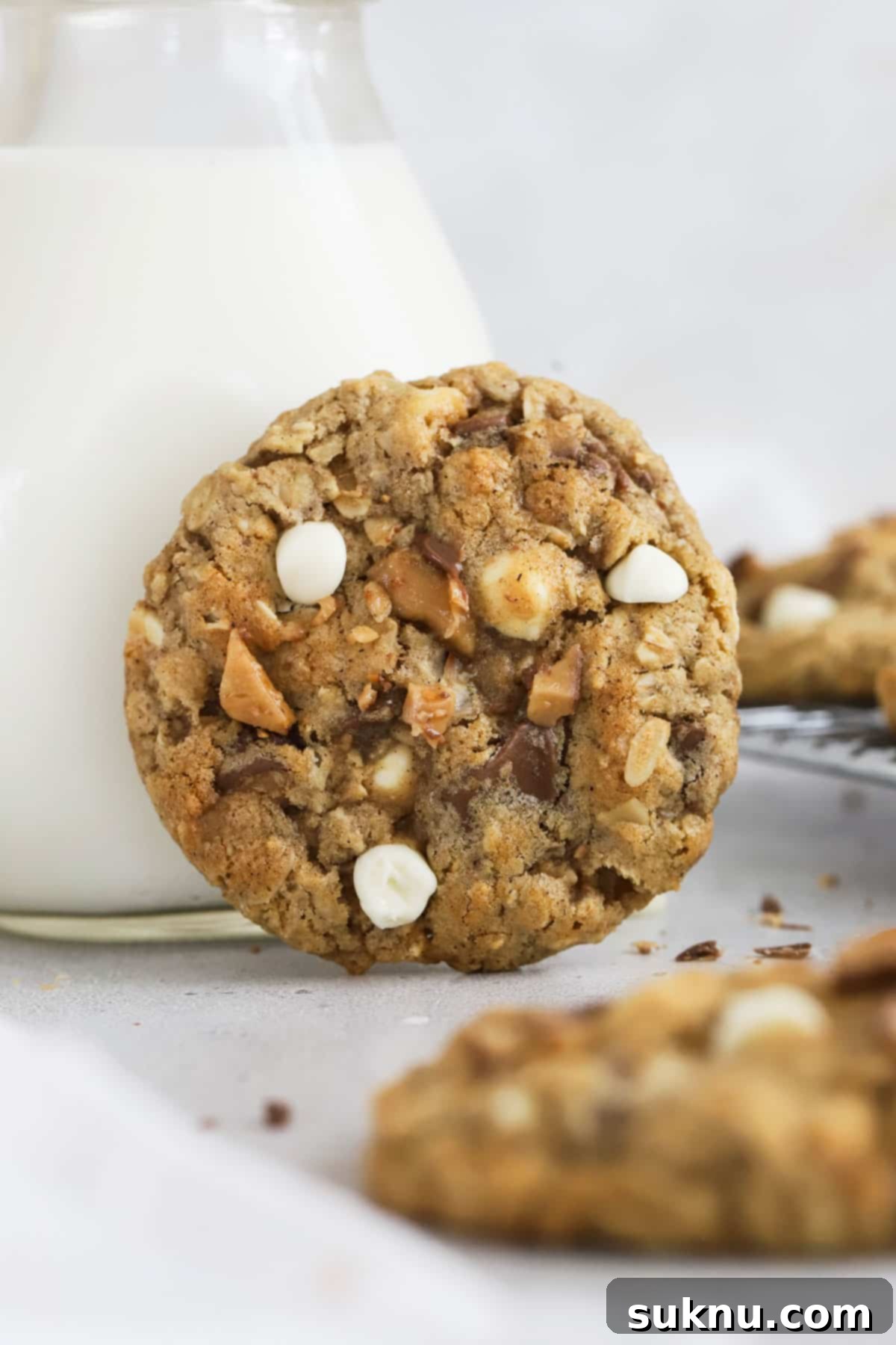 Comforting Gluten-Free Cinnamon White Chocolate Oatmeal Delights 8 gluten-free cinnamon white chocolate chip oatmeal cookies next to a bottle of milk