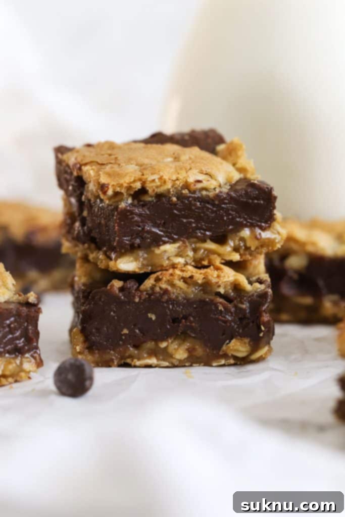 Gluten-Free Kitchen Sink Cookie Bars 11 gluten-free oatmeal fudge cookie bars stacked by a bottle of milk