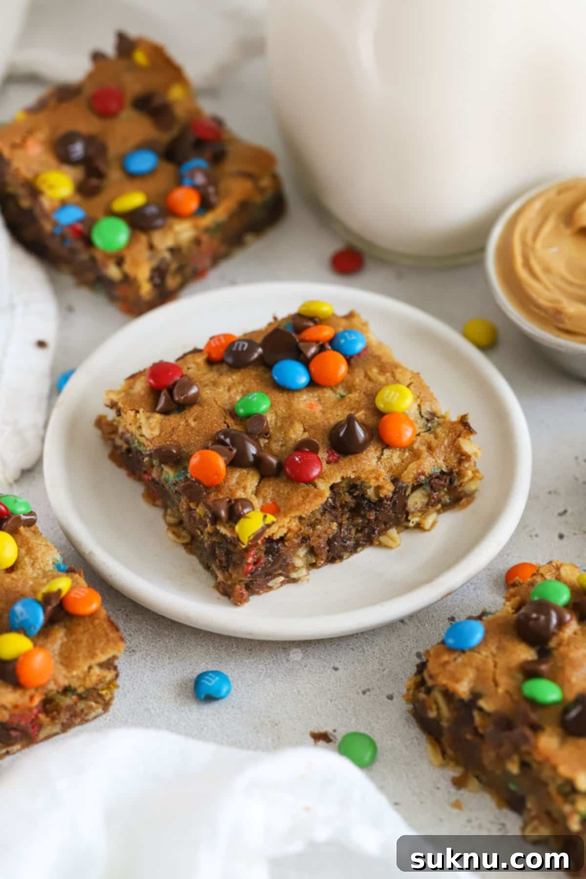 Gluten-Free Kitchen Sink Cookie Bars 14 Gluten-free monster cookie bars next to a bottle of milk