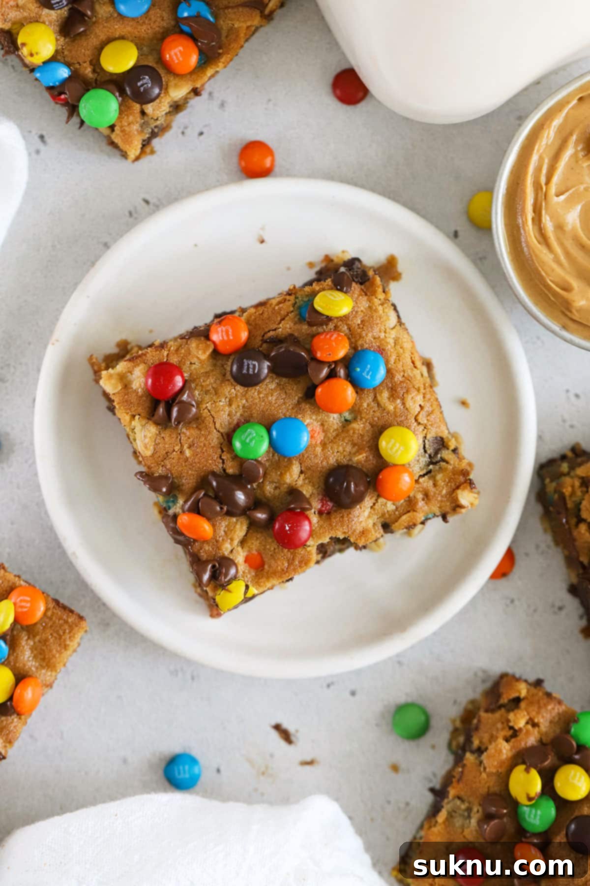 Gluten-Free Kitchen Sink Cookie Bars 8 Gluten-free monster bars on a white dessert plate