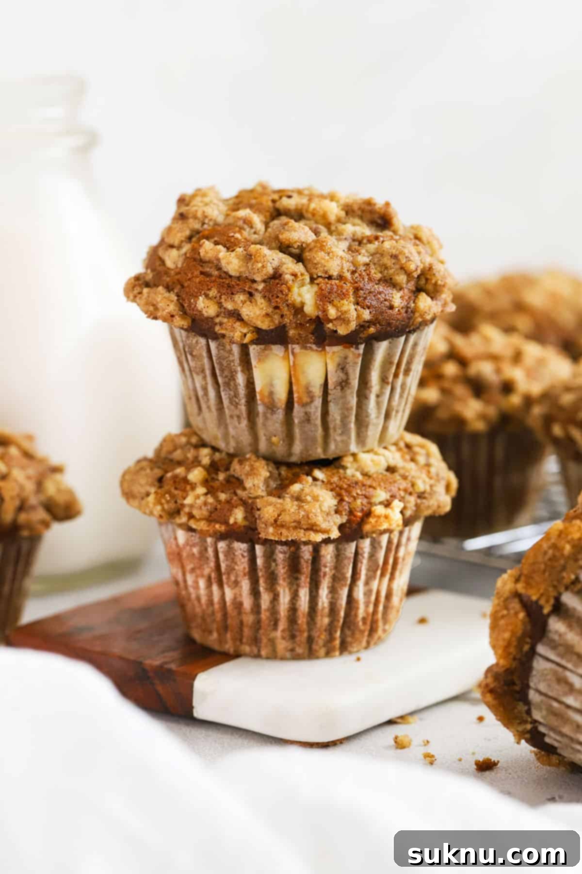 Spiced Gluten-Free Pumpkin Cream Cheese Muffins 14 Two gluten-free pumpkin cream cheese muffins stacked next to a bottle of milk