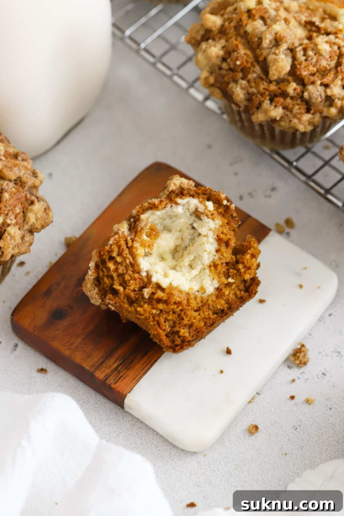 Spiced Gluten-Free Pumpkin Cream Cheese Muffins 9 A gluten-free pumpkin muffin cut in half, revealing the luscious cream cheese filling nestled inside