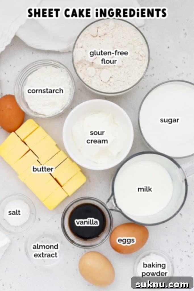A flat lay photograph showcasing all the dry and wet ingredients neatly laid out for baking the gluten-free yellow sheet cake: gluten-free flour, cornstarch, sugar, softened butter, fresh eggs, vanilla extract, sour cream, and whole milk.
