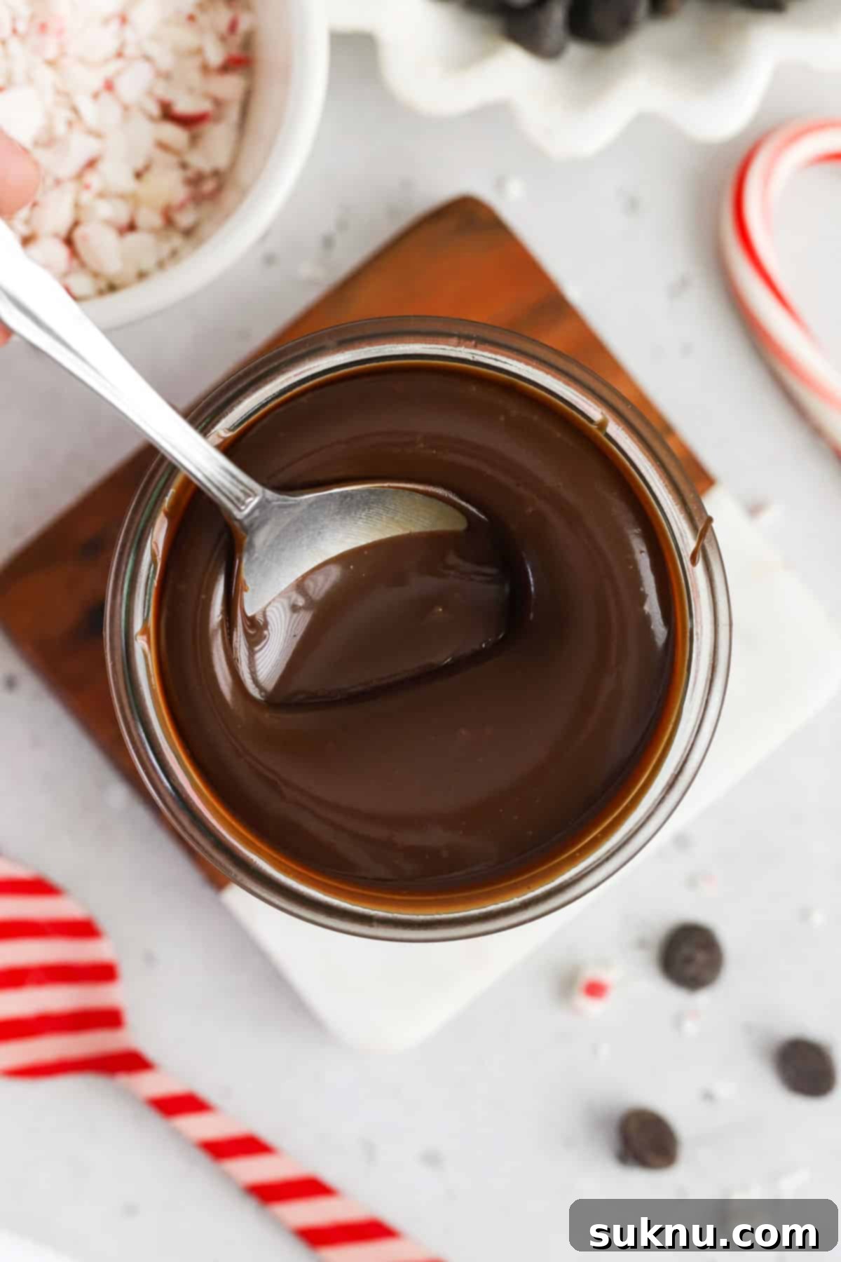 Spoon dipping into a jar of rich peppermint hot fudge sauce