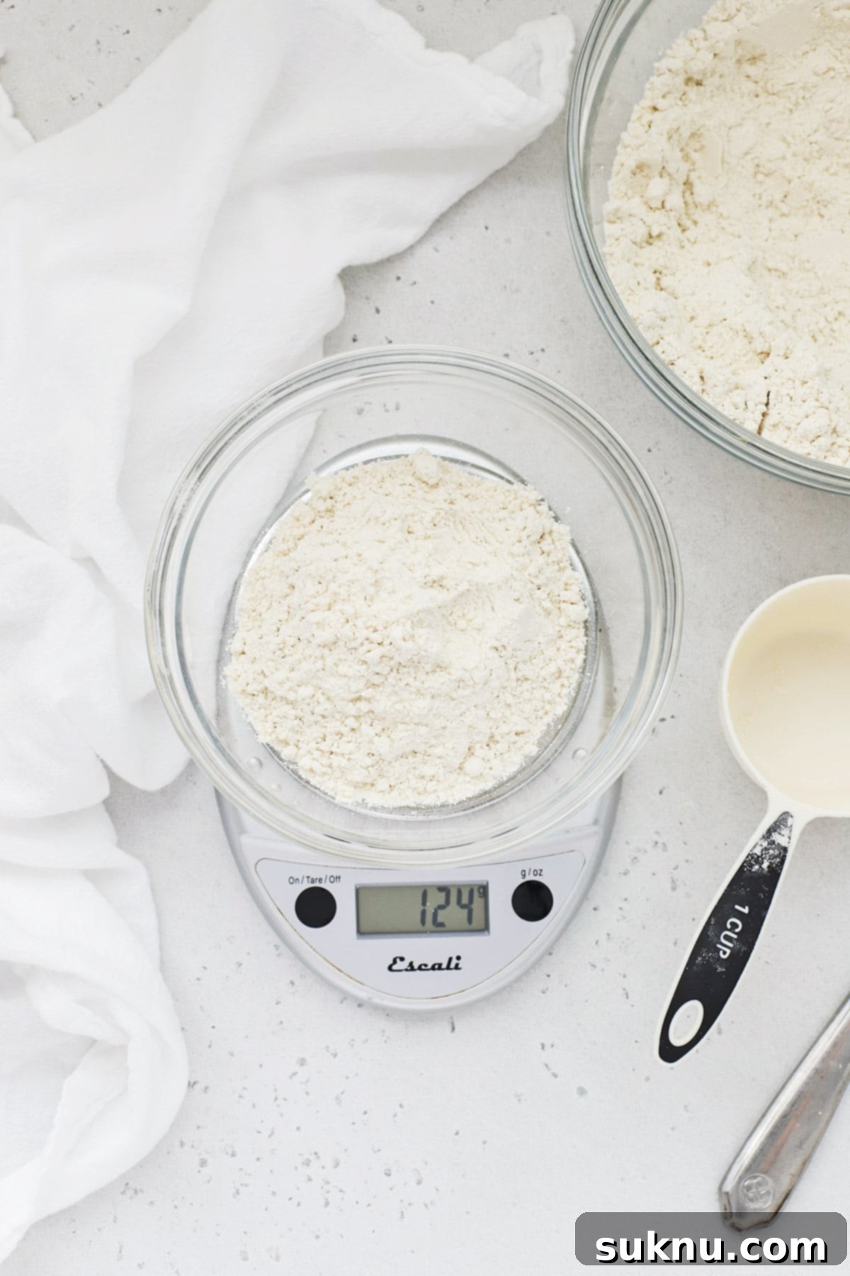 Master Flour Measurement For Perfect Baking 11 Overhead view of a bowl of flour with a measuring cup and scale for demonstrating accurate measurement