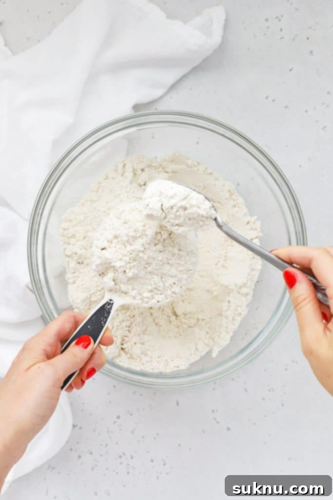 Master Flour Measurement For Perfect Baking 14 Flour unevenly mounded in a measuring cup, demonstrating measurement without proper leveling