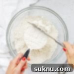 Master Flour Measurement For Perfect Baking 17 Overhead view of someone using the scoop and level method to measure flour correctly