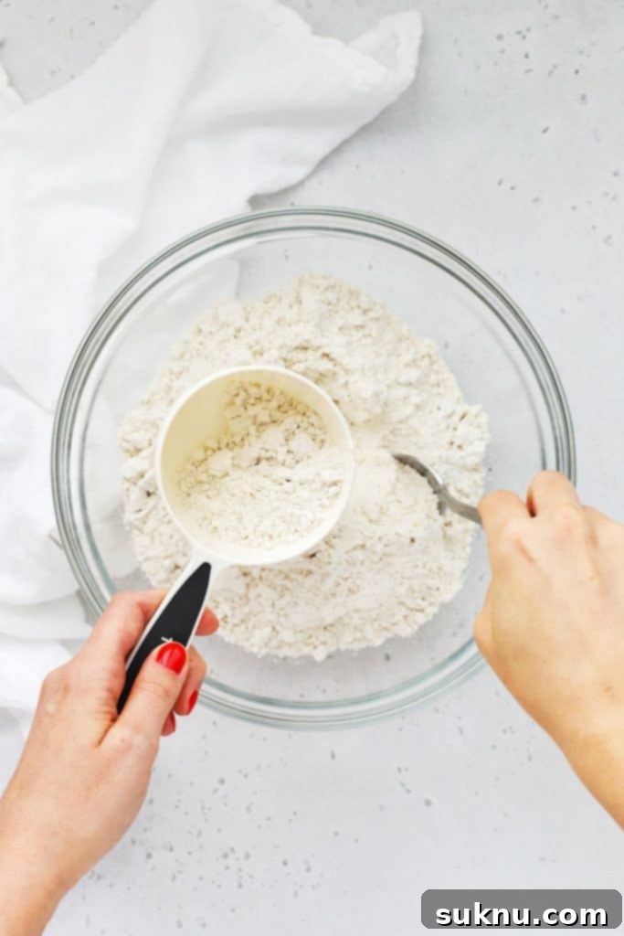 Master Flour Measurement For Perfect Baking 4 A spoon gently scooping flour into a measuring cup