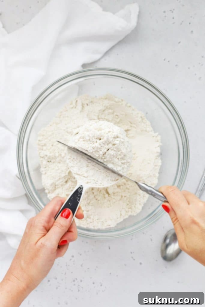 Master Flour Measurement For Perfect Baking 6 A knife being used to level off excess flour from a measuring cup