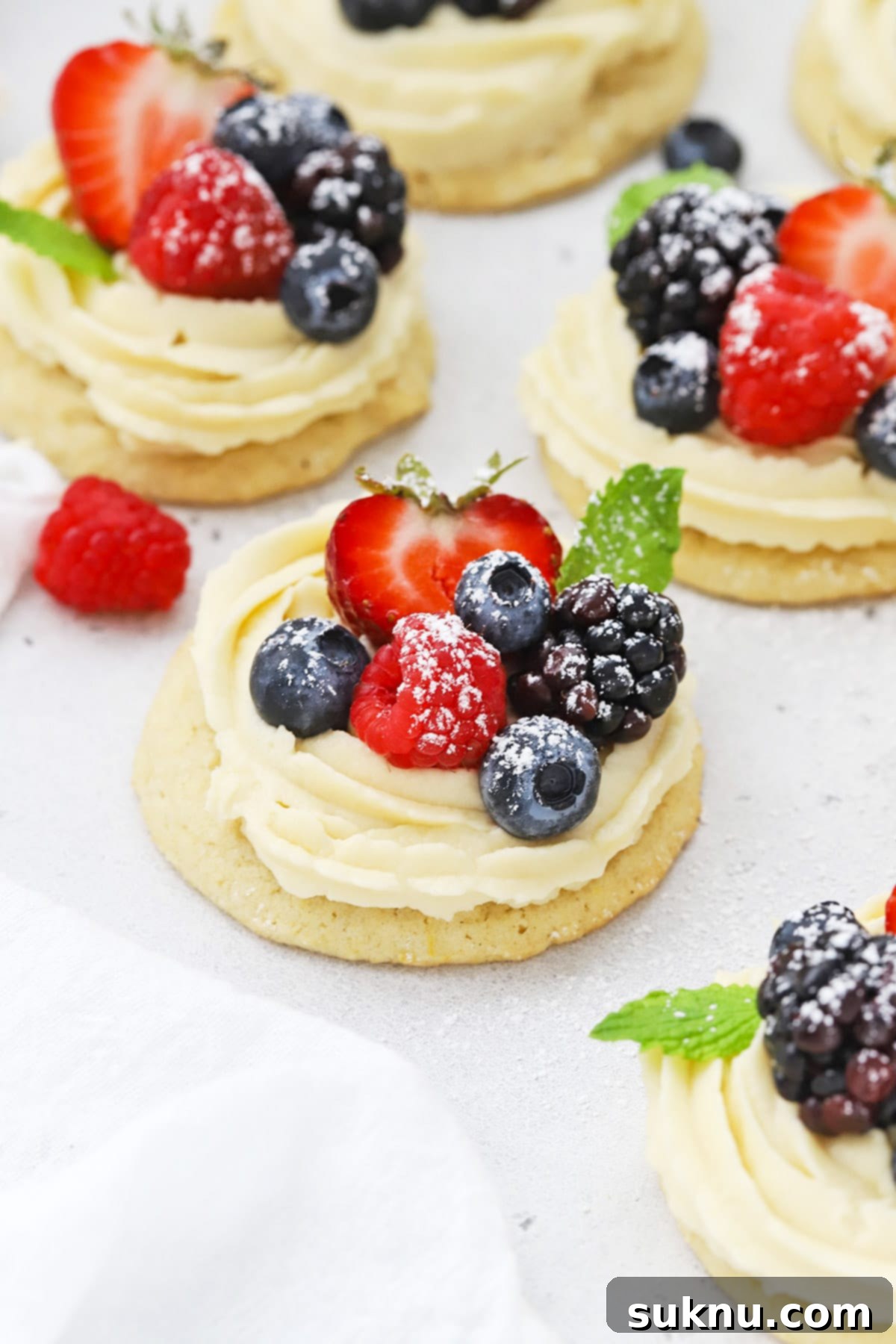 Front view of gluten-free fruit pizza cookies topped with berries and powdered sugar
