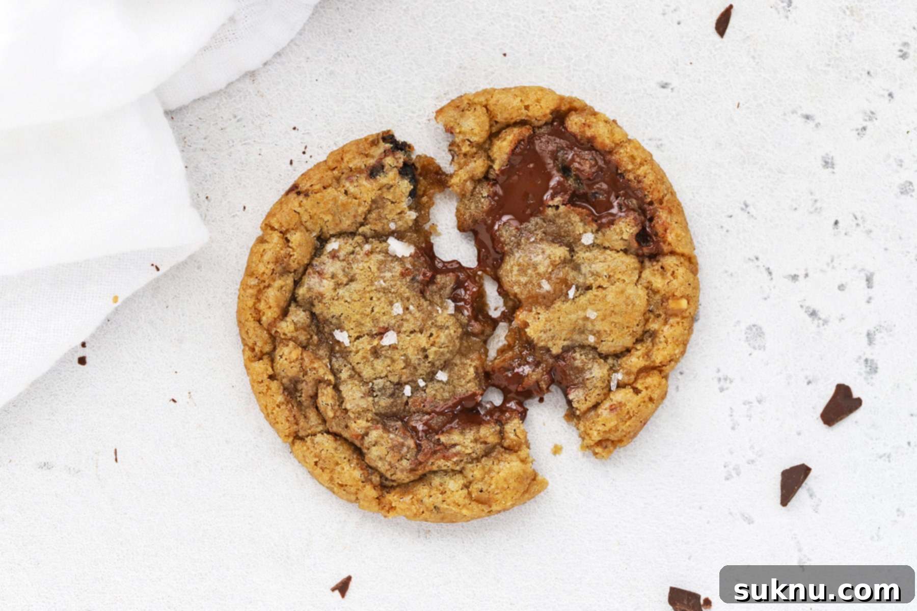 Overhead image of a gooey gluten-free brown butter toffee chocolate chip cookie being pulled apart