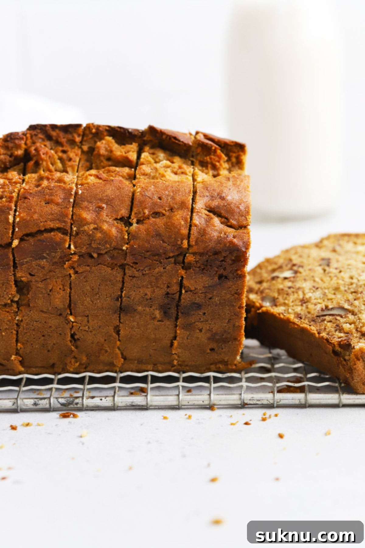 Side view of a perfectly sliced loaf of gluten-free brown butter banana bread, showing its moist crumb.