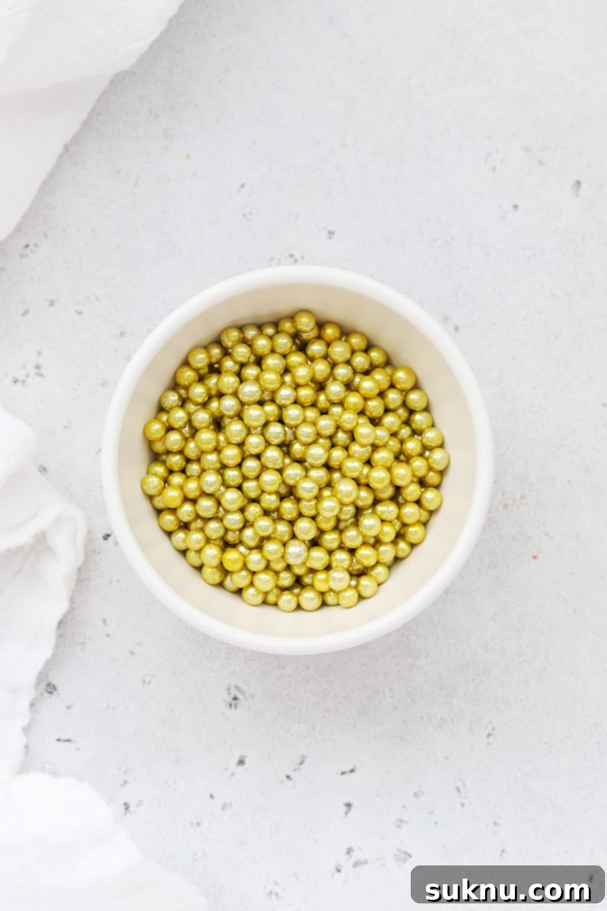 Gold dragees sprinkles in a white bowl