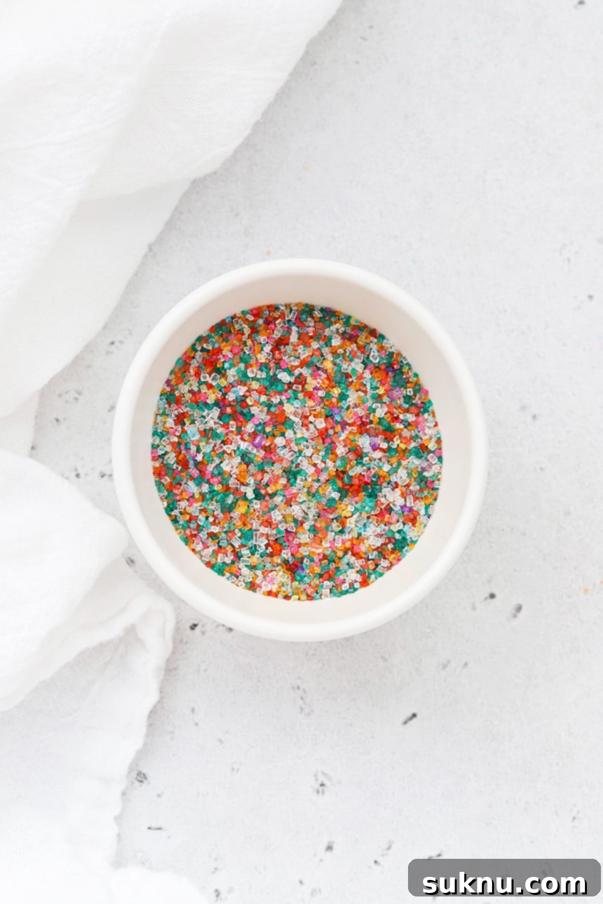 Colorful sparkling sugar sprinkles in a white bowl