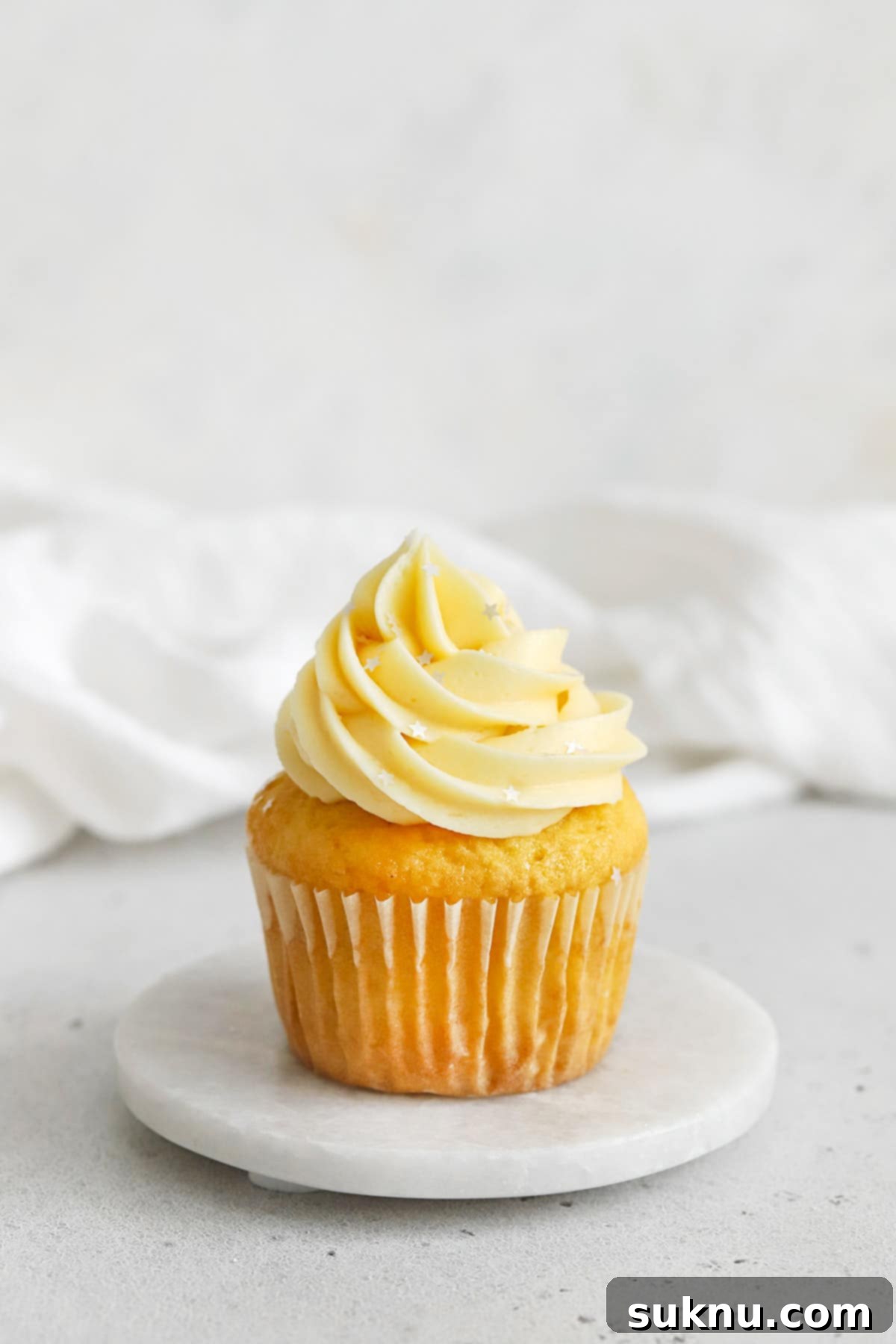 gluten-free vanilla cupcake topped with vanilla buttercream and edible silver star glitter
