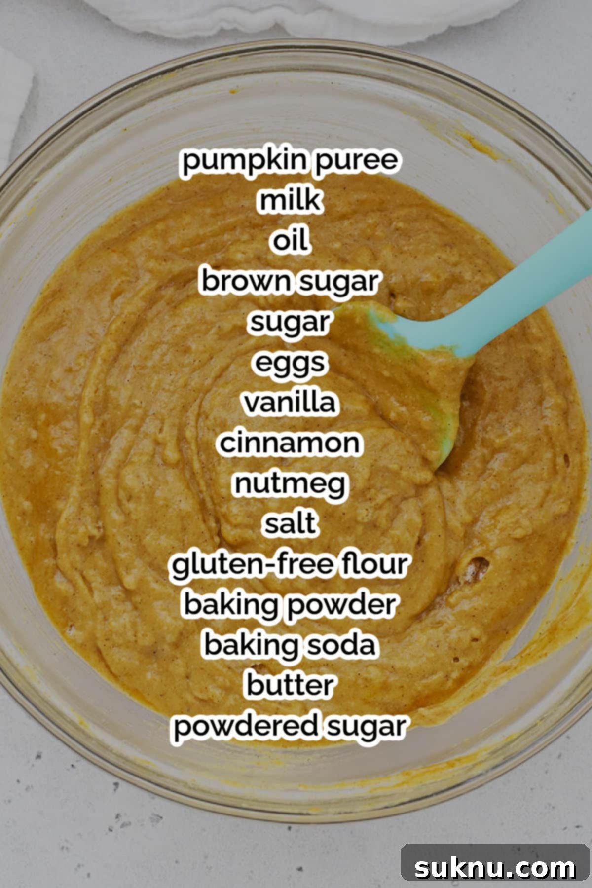 Assorted ingredients for gluten-free pumpkin streusel bread laid out on a kitchen counter, including canned pumpkin, milk, oil, sugars, eggs, vanilla, spices, and a bag of gluten-free flour