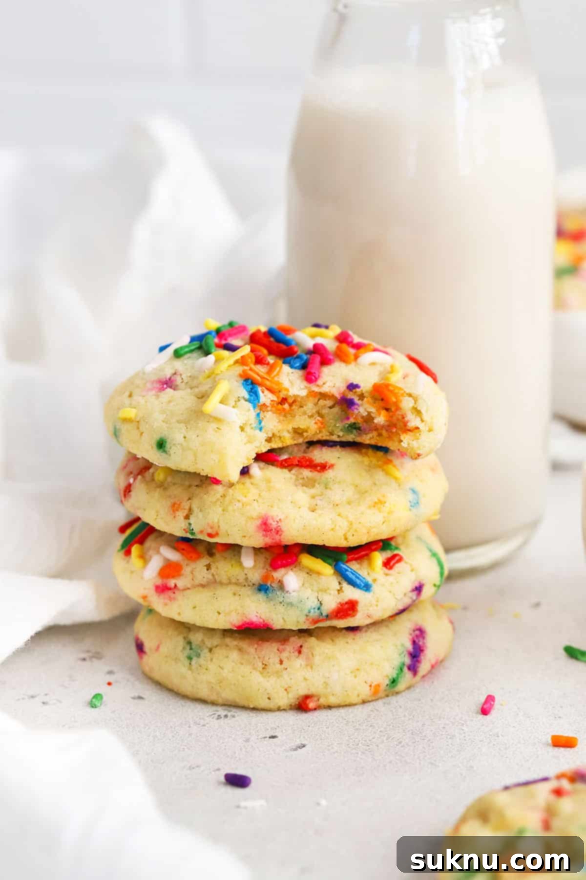 Sprinkled Gluten Free Sugar Cookies 2 A stack of vibrant gluten-free sugar cookies adorned with colorful sprinkles, promising a delicious treat for any celebration.
