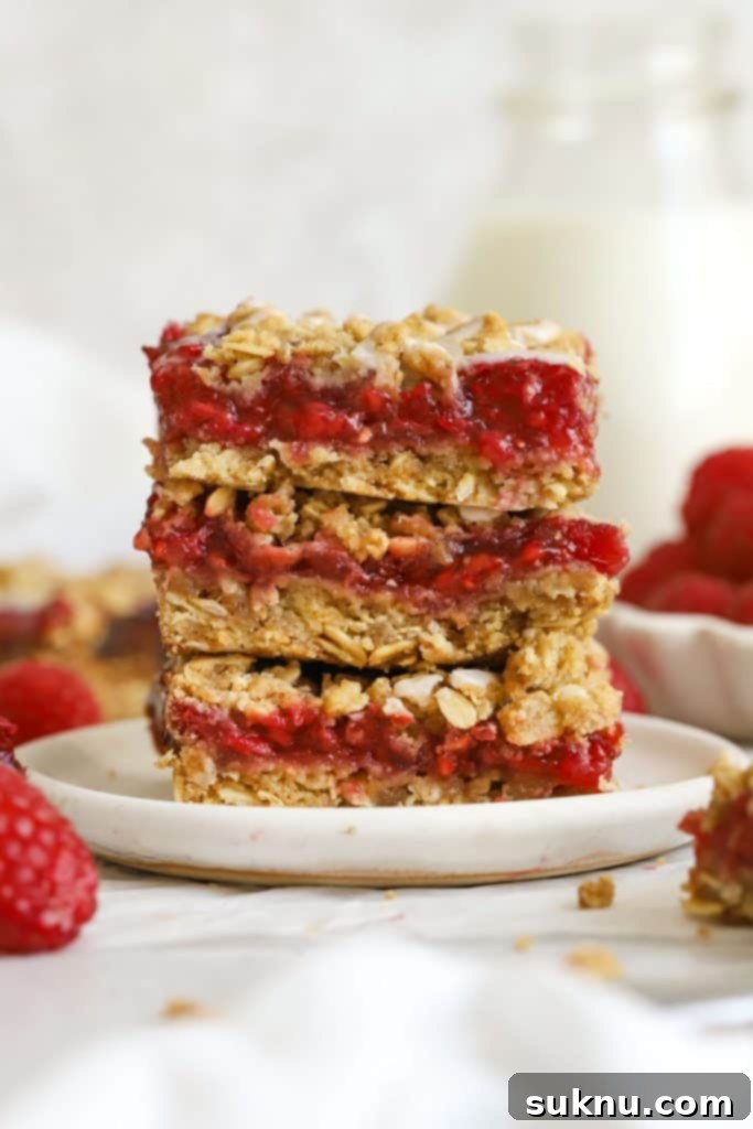 Sweet and Salty Gluten-Free Pecan Caramel Treats 14 three gluten-free raspberry crumble bars stacked on a white plate