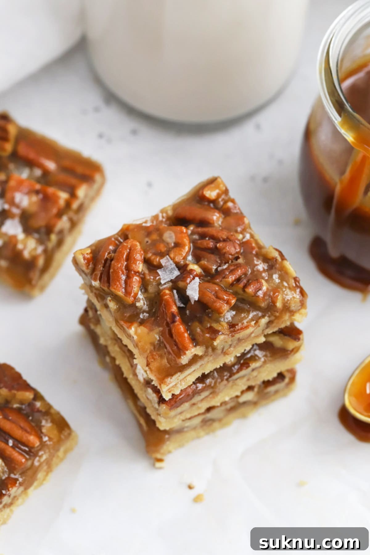 Sweet and Salty Gluten-Free Pecan Caramel Treats 8 Front view of three stacked gluten-free salted caramel pecan bars with a rich brown sugar shortbread crust