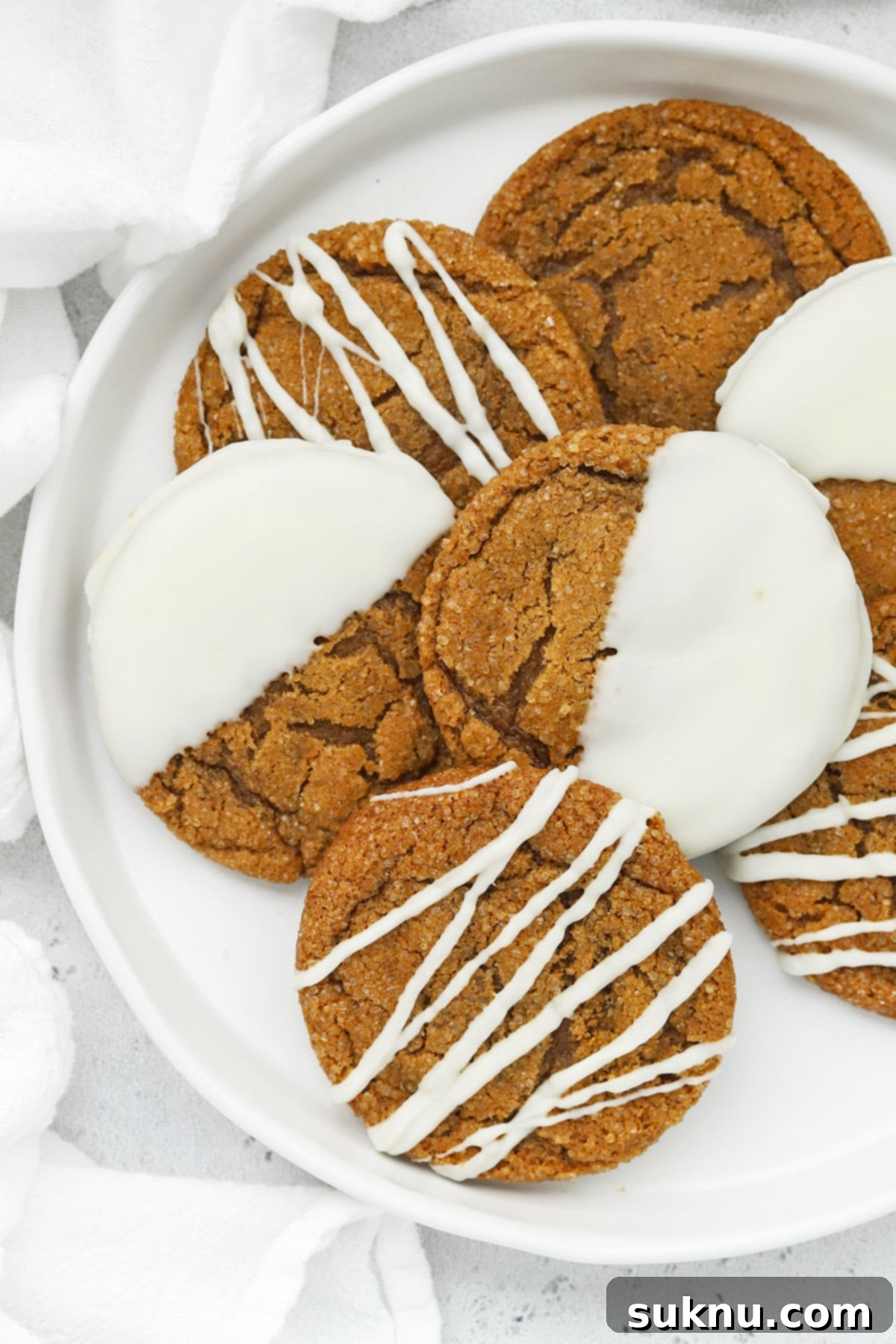 Overhead view of soft, chewy gluten-free ginger cookies drizzled and dipped in white chocolate
