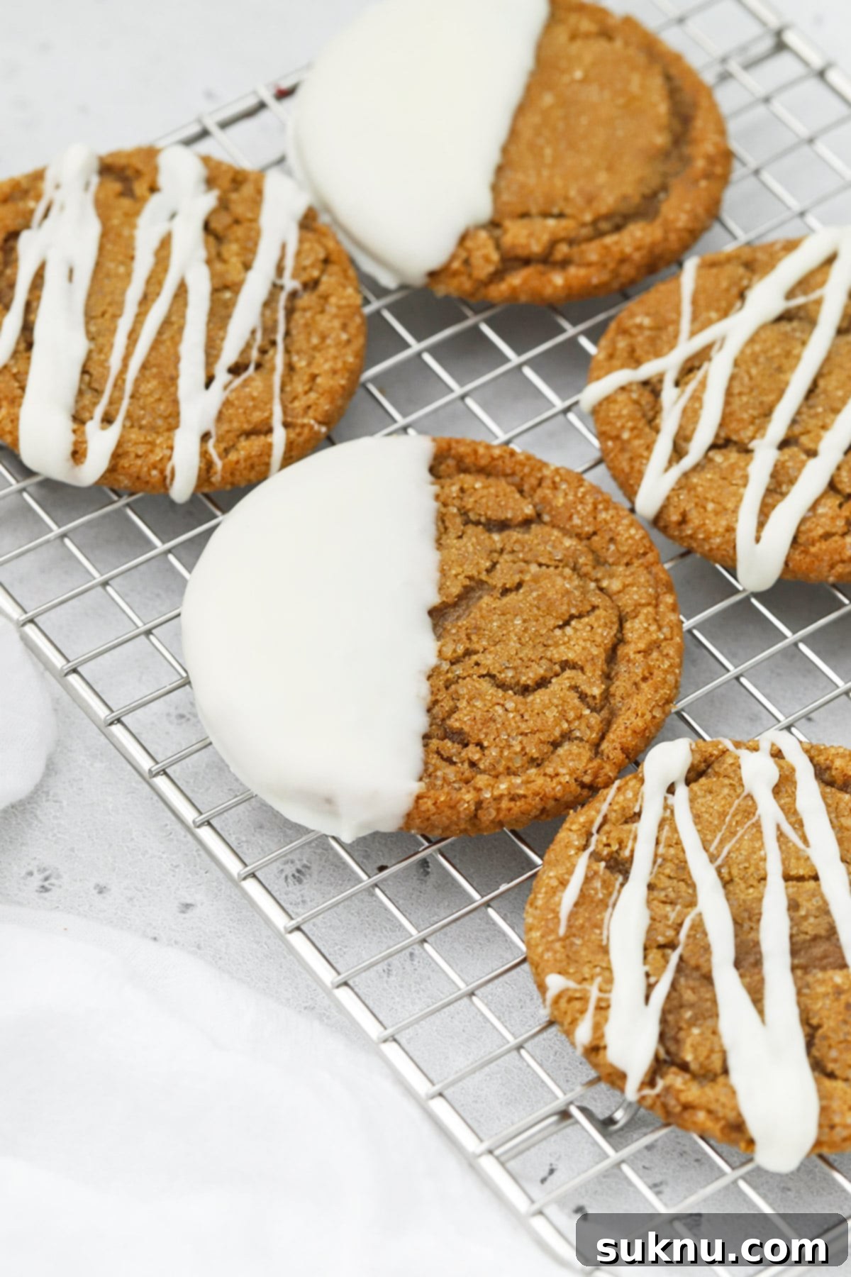 Front view of soft, chewy gluten-free ginger cookies drizzled and dipped in white chocolate