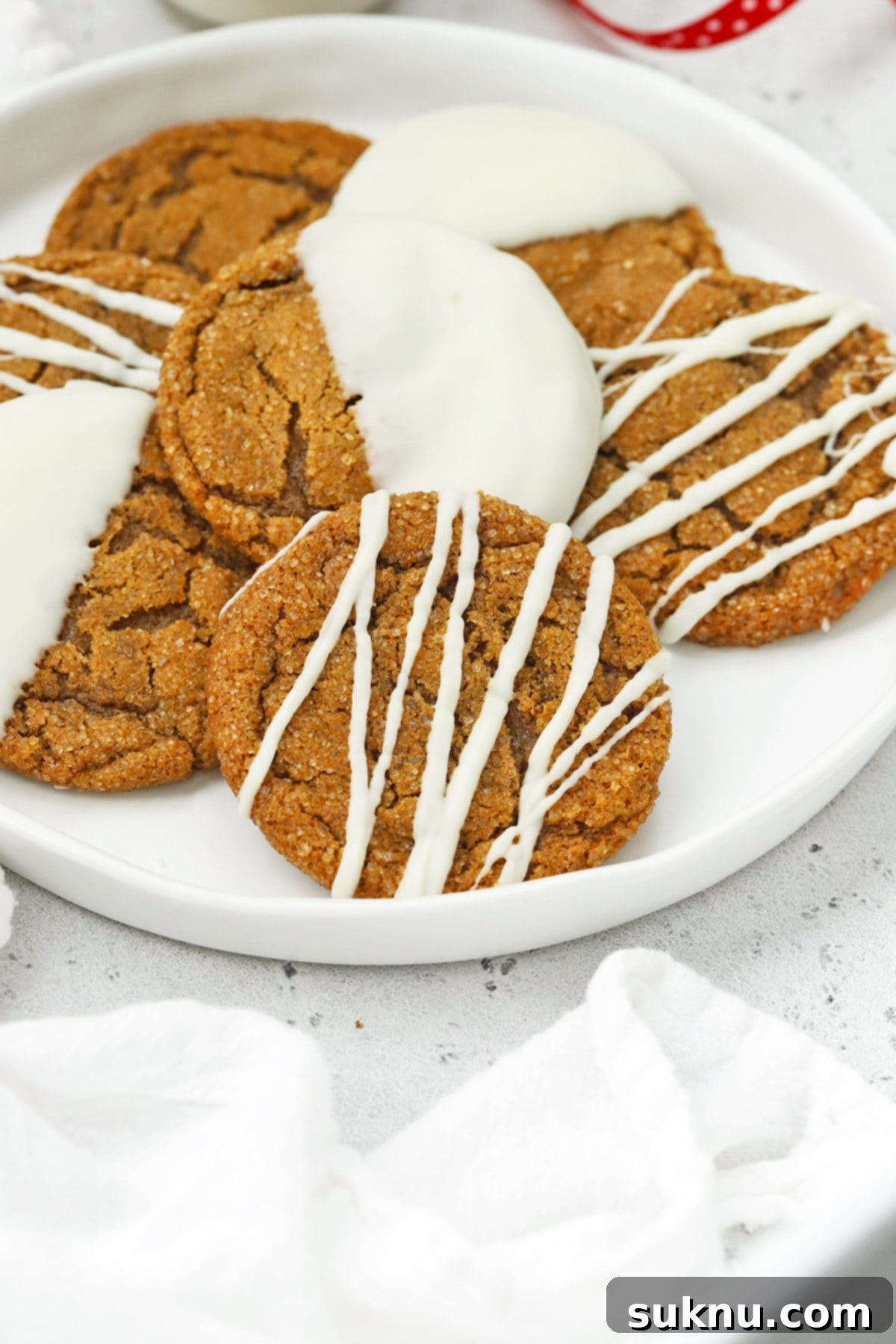Front view of soft, chewy gluten-free ginger cookies drizzled and dipped in white chocolate