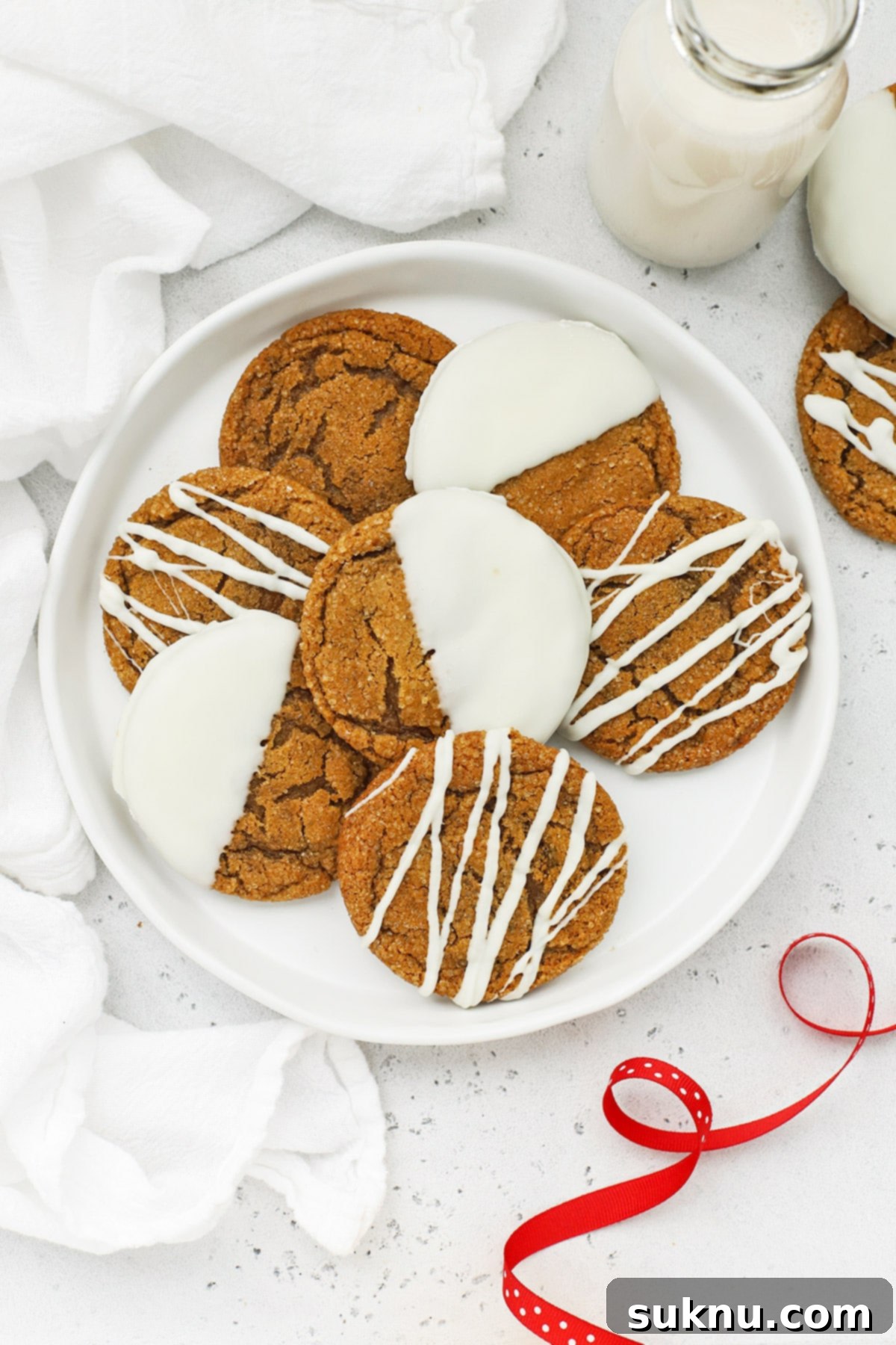 Overhead view of soft, chewy gluten-free ginger cookies drizzled and dipped in white chocolate