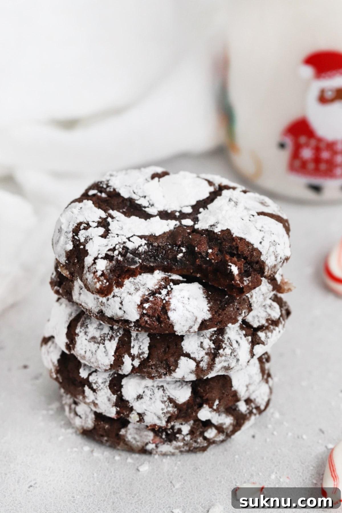 Stack of gluten-free peppermint chocolate crinkle cookies, showcasing their height and appealing festive look.