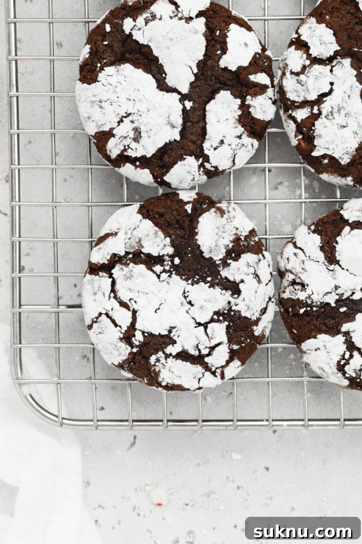 Overhead view of gluten-free peppermint chocolate crinkle cookies cooling on a wire rack, ready to be enjoyed.