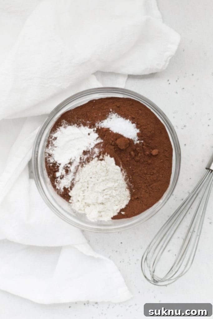 Overhead view of dry ingredients for peppermint chocolate crinkle cookies, neatly arranged in separate bowls.