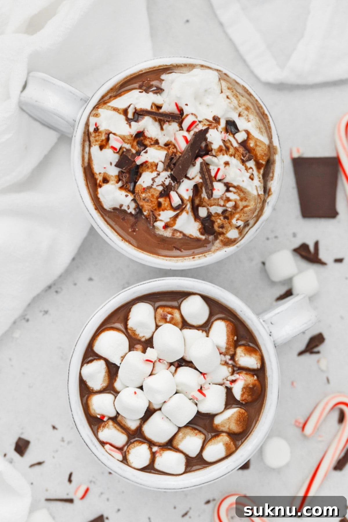Peppermint Dream Vegan Cocoa 9 Overhead shot of two mugs of vegan peppermint hot chocolate, one generously topped with fluffy marshmallows, and the other with smooth coconut whipped cream.