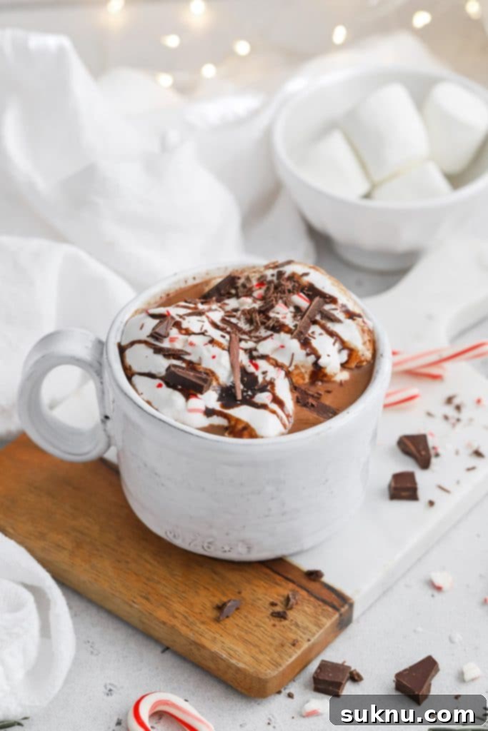 Peppermint Dream Vegan Cocoa 10 Front view of a beautiful cup of steaming vegan peppermint hot chocolate, topped with a generous swirl of white whipped cream and a sprinkle of chocolate shavings, from Sweets & Thank You.