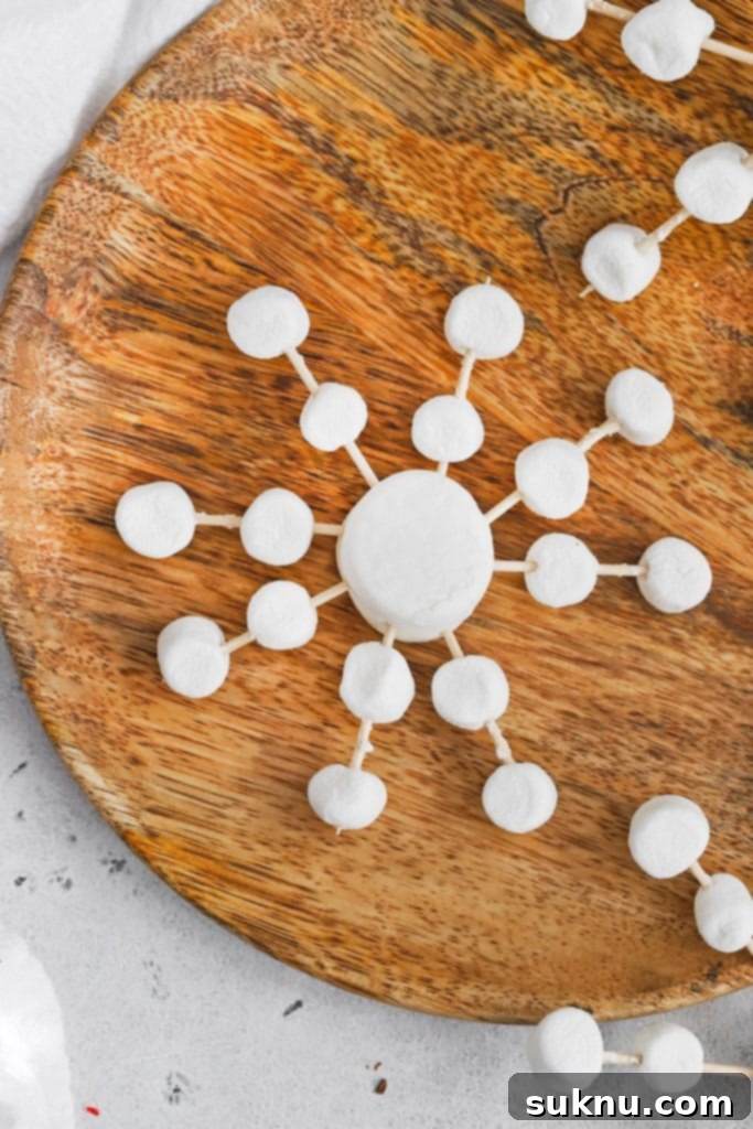 Marshmallow Snowflake Magic 13 Overhead view of several marshmallow snowflakes arranged artfully on a surface.