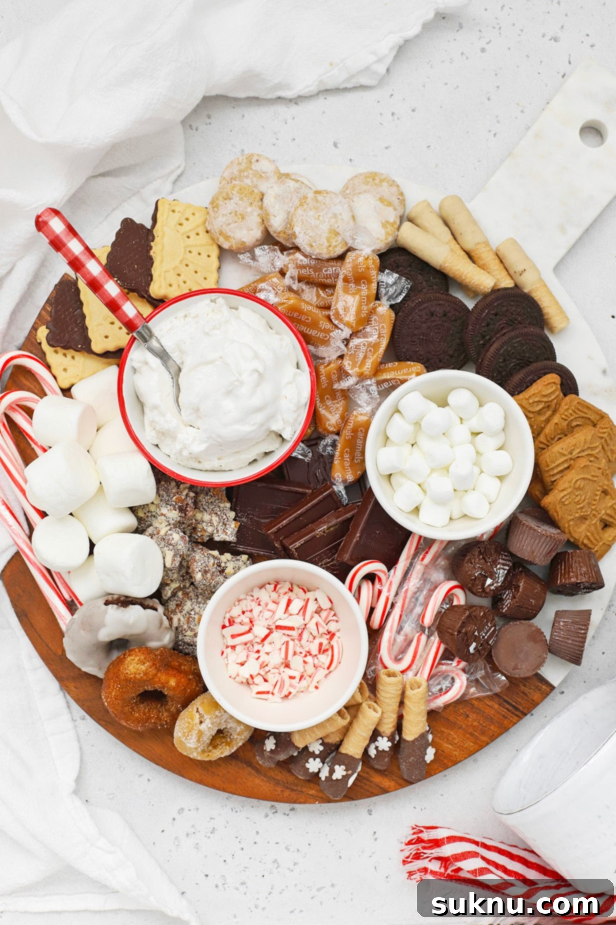 An overhead view of a beautifully arranged gluten-free hot chocolate charcuterie board, laden with a variety of colorful and delicious toppings and mix-ins, ready for a cozy winter gathering.