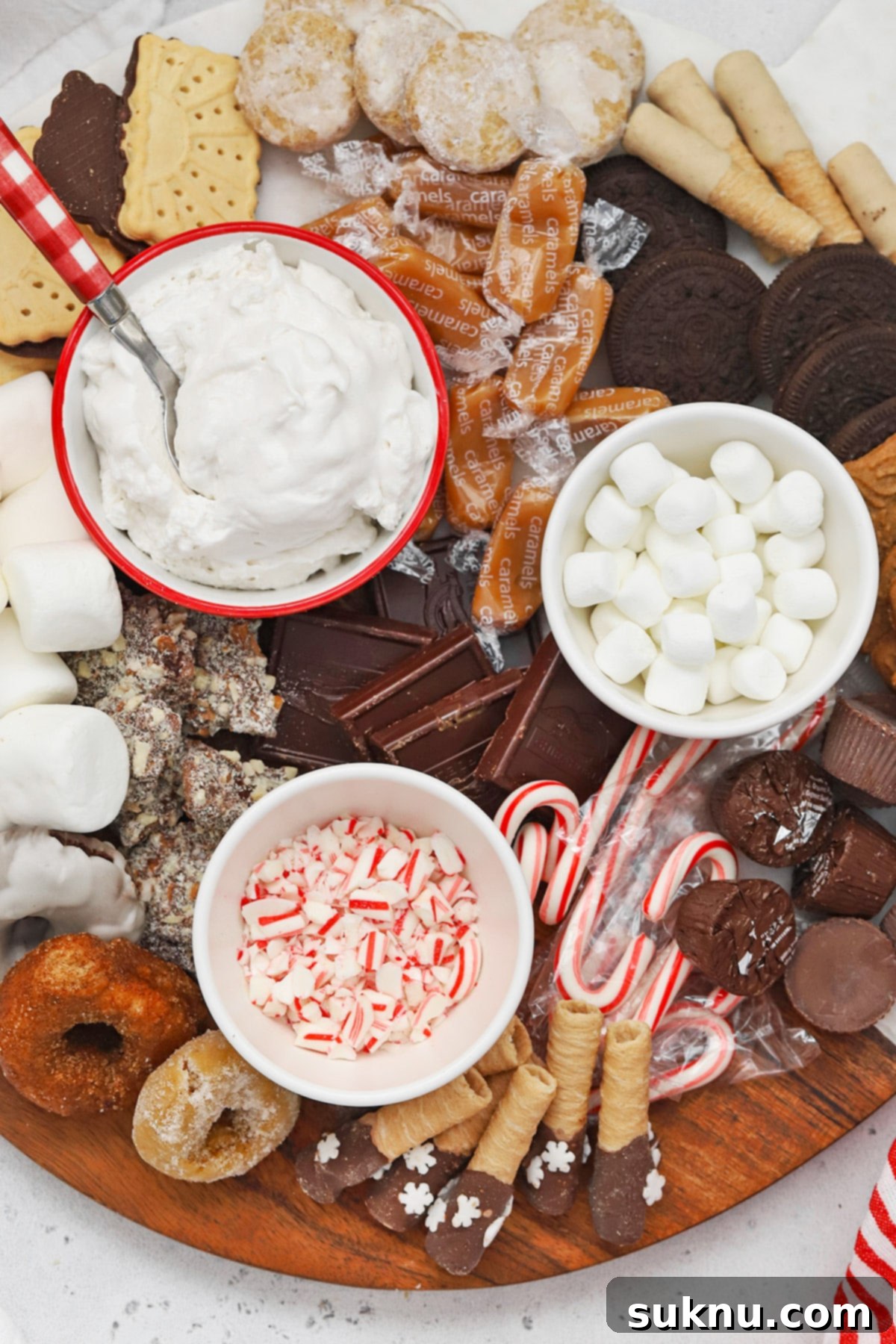 An inviting overhead shot of a gluten-free hot chocolate charcuterie board, featuring a rich assortment of gluten-free cookies, marshmallows, chocolate pieces, and other festive toppings.