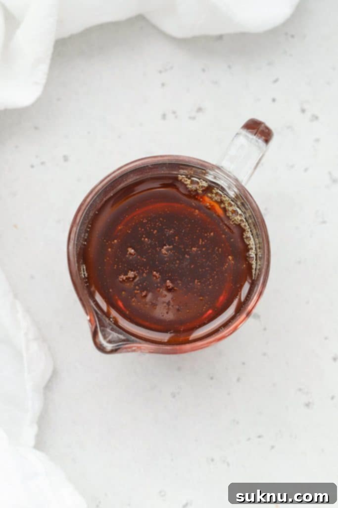 Holiday Gluten Free Eggnog French Toast Bake 11 Overhead view of a small glass pitcher filled with pure maple syrup, ready to be drizzled over a warm breakfast