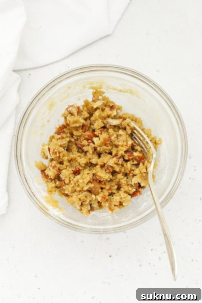 Holiday Gluten Free Eggnog French Toast Bake 7 An overhead view of a small bowl containing a brown sugar pecan streusel mixture, ready to top the gluten-free baked french toast casserole