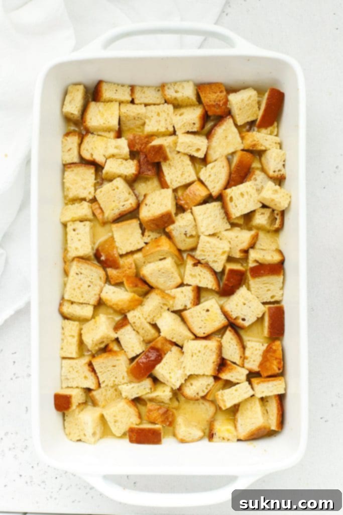 Holiday Gluten Free Eggnog French Toast Bake 8 An overhead view of gluten-free eggnog baked french toast casserole in a baking dish, pre-streusel, ready to go into the oven
