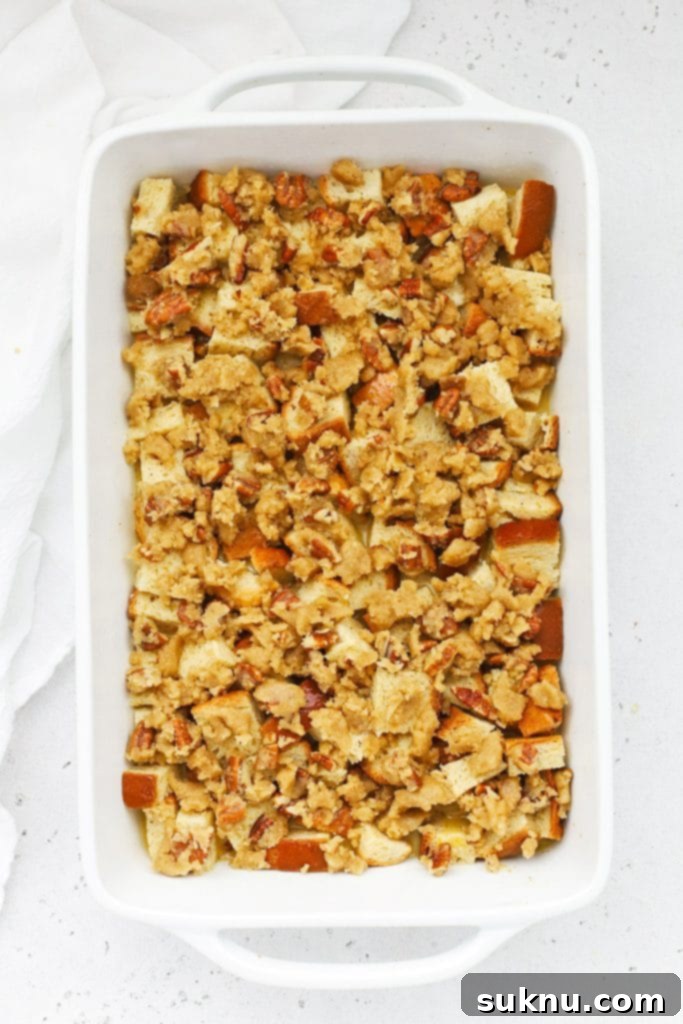 Holiday Gluten Free Eggnog French Toast Bake 9 An overhead view of gluten-free eggnog french toast casserole topped with a generous layer of pecan brown sugar streusel, ready for baking