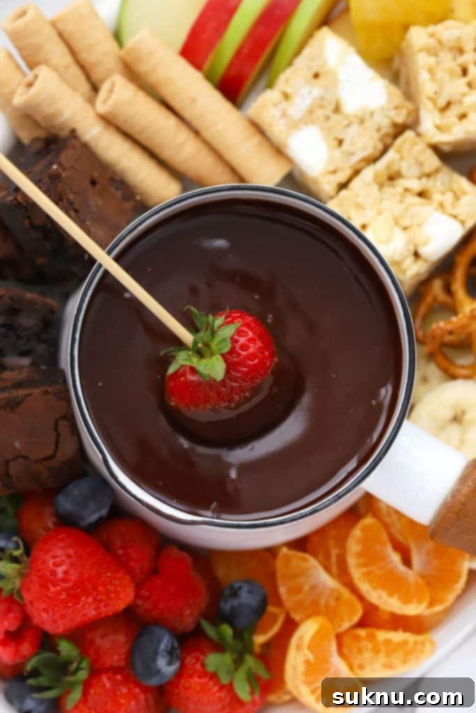 Brown Sugar Cream Cheese Fruit Dream 16 A fresh strawberry being dipped into a rich, melted gluten-free chocolate fondue