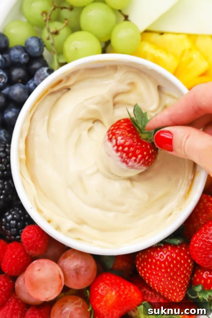 Brown Sugar Cream Cheese Fruit Dream 9 Close-up of Brown Sugar Cream Cheese Fruit Dip in a bowl, with a single strawberry being dipped in