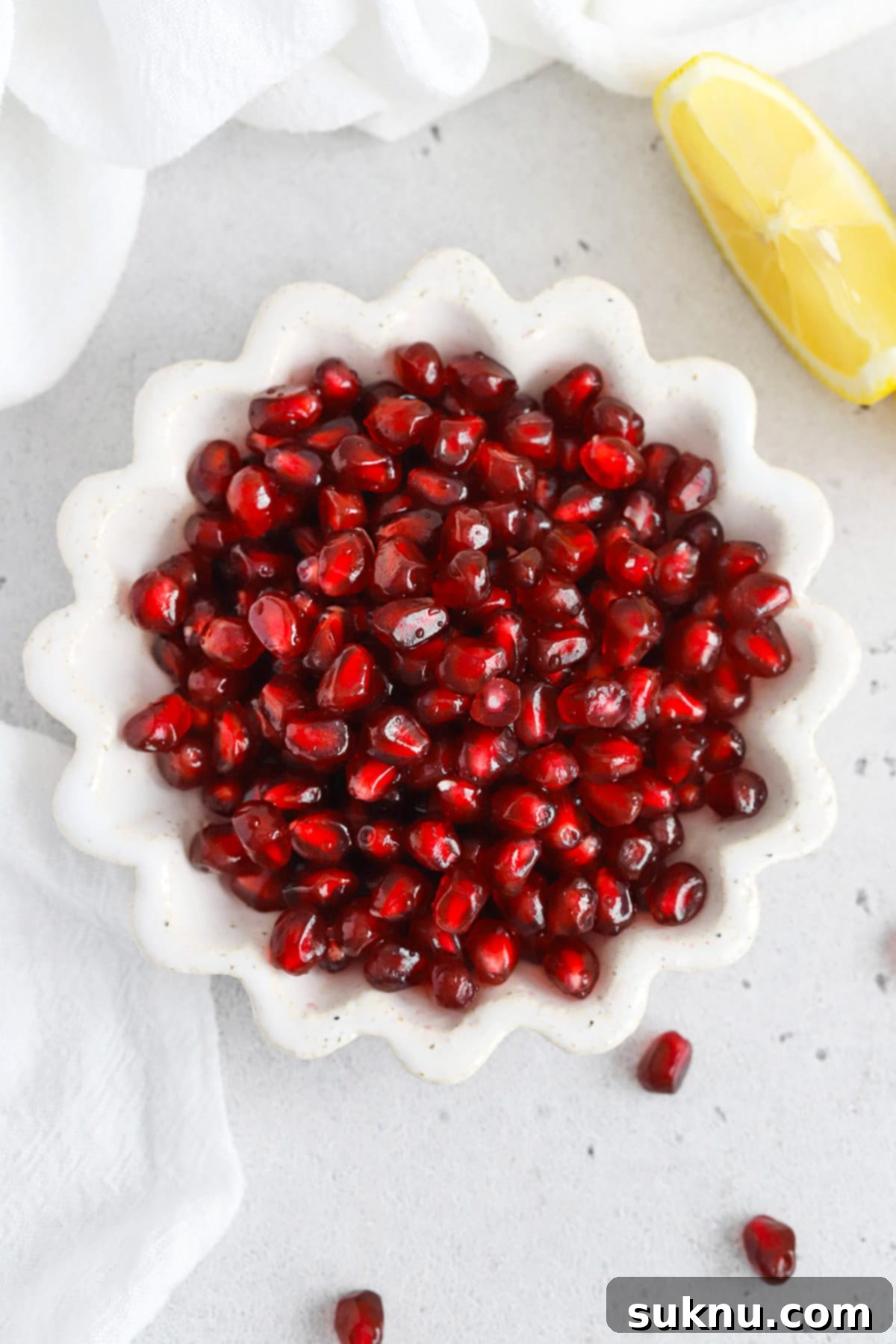 Easy Homemade Grenadine Three Ingredients 6 Overhead view of a ruffled white bowl of pomegranate arils