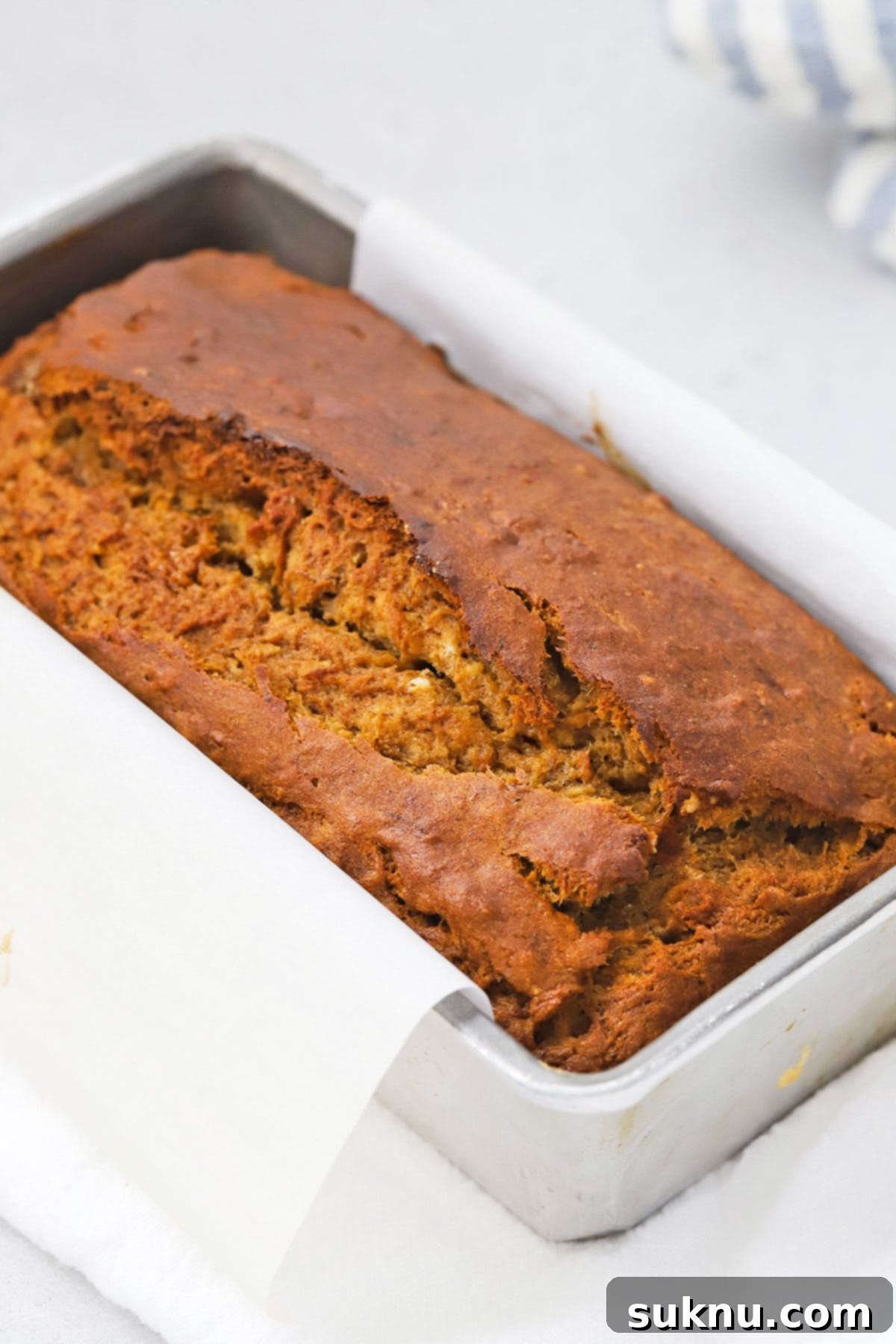 A freshly baked loaf of gluten-free brown butter banana bread, showcasing its perfect golden crust and moist texture.