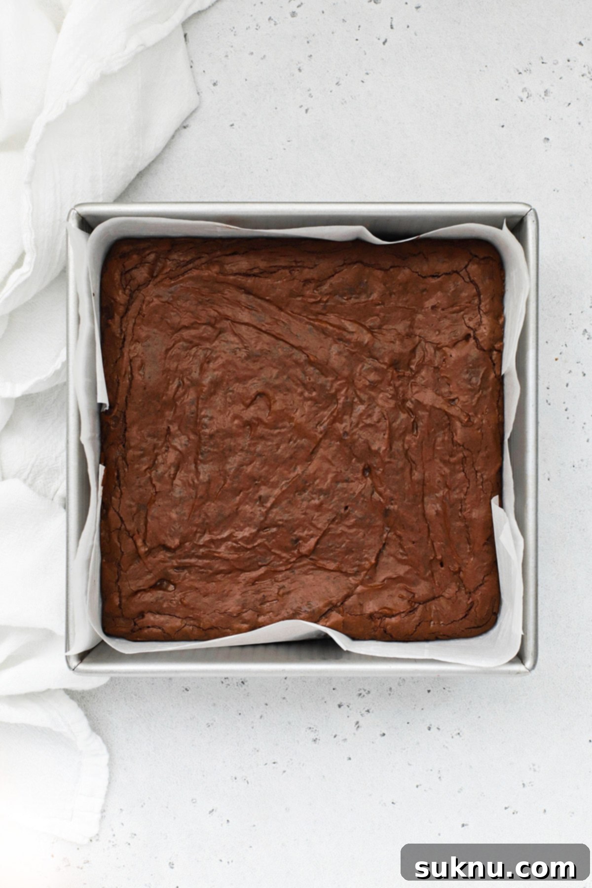 Overhead view of a pan of freshly baked, fudgy gluten-free brownies, cooling and ready for the next layers.