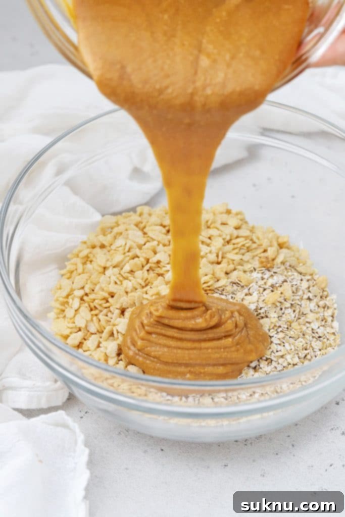 Pouring the peanut butter into the dry ingredients for homemade peanut butter granola bars