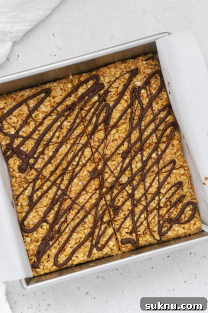 Drizzling peanut butter granola bars with melted chocolate