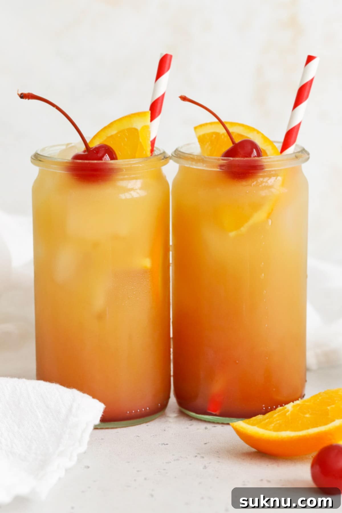 Front view of several non-alcoholic sweet sunrise mocktails, beautifully layered and garnished