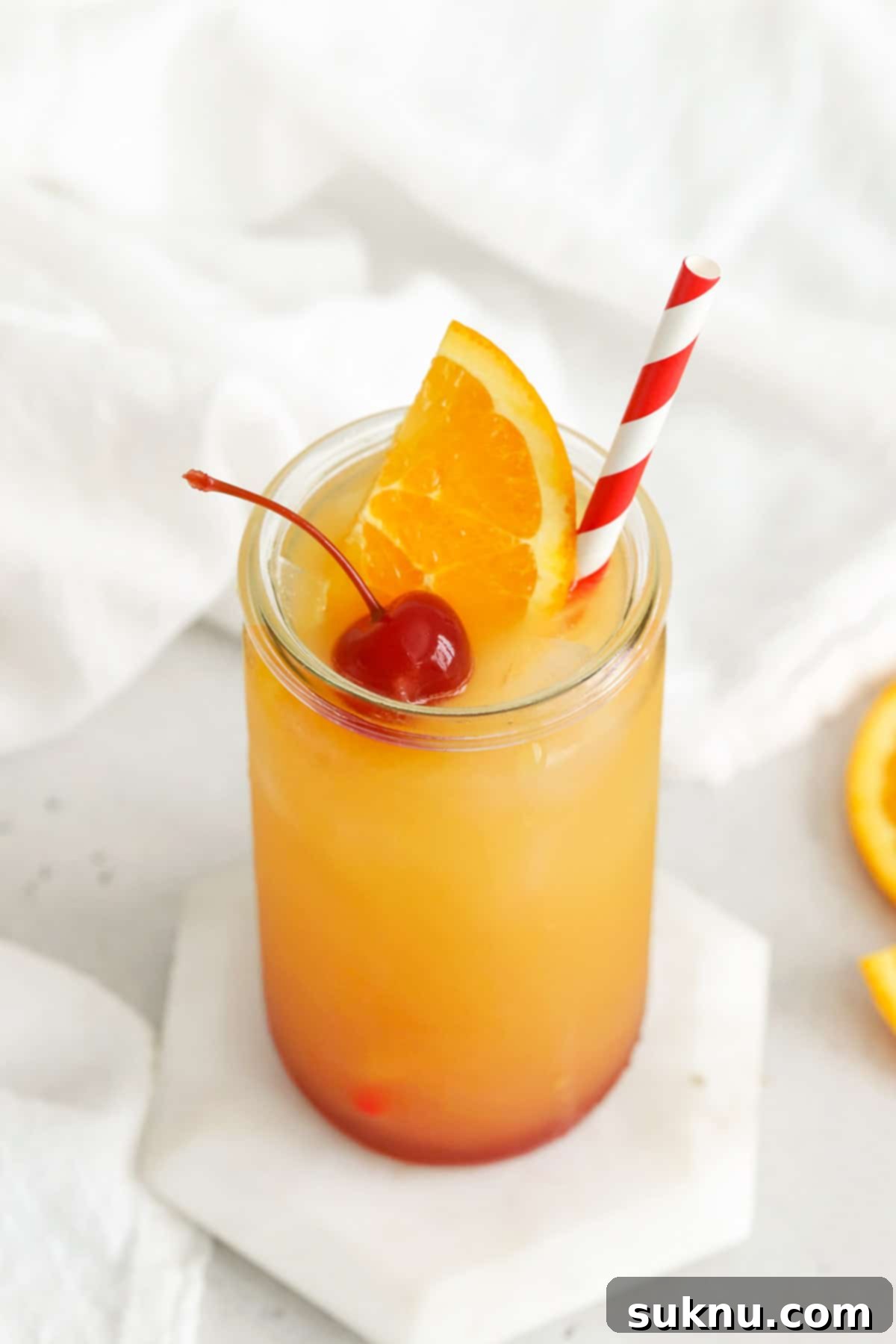 Front view of a refreshing virgin sunrise mocktail from Sweets & Thank You, ready to be enjoyed