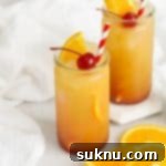 Front view of Sweets & Thank You Sweet Sunrise Mocktail garnished with orange and maraschino cherry
